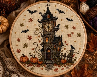 Può includere: Un telaio da ricamo circolare in legno contenente un disegno a punto croce di un'alta torre dell'orologio scura circondata da pipistrelli in volo, zucche arancioni e foglie autunnali sparse su uno sfondo di tessuto beige chiaro.