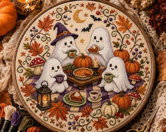 May include: A circular cross-stitch embroidery in a wooden hoop featuring four white ghosts having a picnic on a purple and white checkered blanket. The scene includes orange pumpkins, autumn leaves, mushrooms, a lantern, and slices of pie.