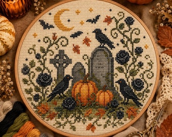 May include: A circular wooden embroidery hoop containing a cross-stitch pattern of a graveyard scene. The design features two grey tombstones, three black crows, two orange pumpkins, dark blue roses, green vines, and a yellow crescent moon.