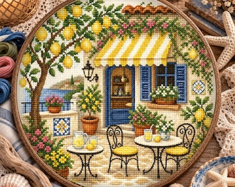 Può includere: Un telaio da ricamo circolare contenente un motivo a punto croce di una scena da bar mediterraneo. Il design presenta un albero di limoni, una tenda a righe gialle e bianche, persiane blu, due tavolini con limonata e sedie.