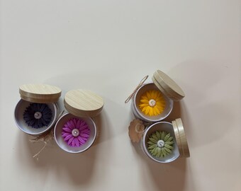 Handmade scented candle in a tin with a flower