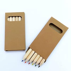 May include: Two kraft paper boxes, one open and one closed, each containing coloured pencils. The pencils have natural wood barrels and coloured tips. The open box displays the coloured tips, while the closed box shows the pencil ends.