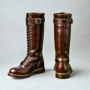 Könnte beinhalten: Ein Paar kniehohe Stiefel aus dunkelbraunem Leder mit Schnürung, Metallösen und einem Riemen mit Schnalle am oberen Schaft. Die Stiefel haben eine abgerundete Zehenpartie, einen Blockabsatz und eine glatte Oberfläche mit sichtbaren Nähten.