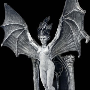 Pode incluir: Uma figura branca esculpida de uma mulher alada com os bra&ccedil;os estendidos, em p&eacute; sobre um pedestal de pedra com um arco g&oacute;tico atr&aacute;s dela.