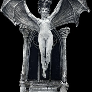 Pode incluir: Uma est&aacute;tua de uma figura feminina alada branca com um arco g&oacute;tico e degraus. A est&aacute;tua &eacute; feita de resina e tem um acabamento detalhado e texturizado.