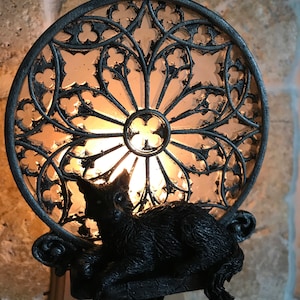 Peut inclure: Une veilleuse en forme de chat noir avec un motif de vitrail. Le chat est assis sur un rebord avec une ampoule &agrave; l'int&eacute;rieur du cercle de vitrail.
