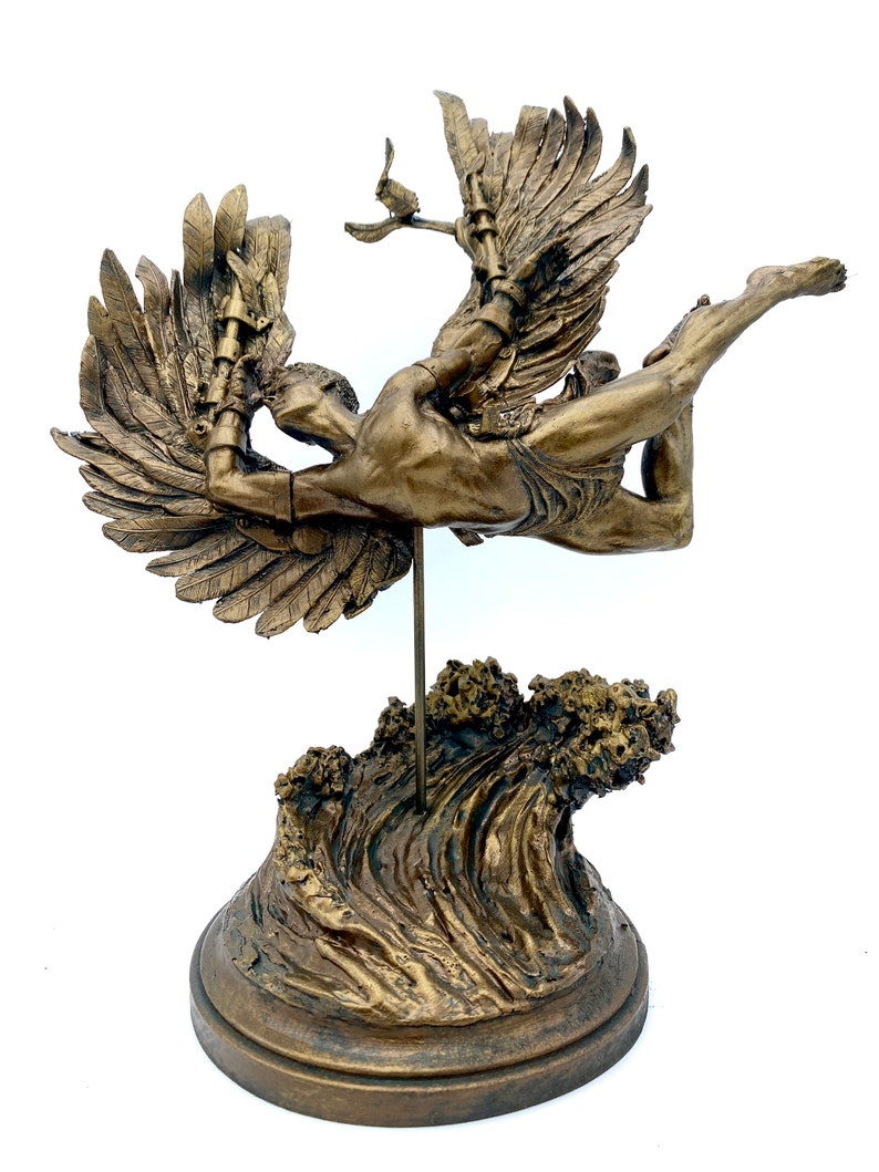 May include: A bronze sculpture of a winged figure with outstretched arms, standing on a wave-shaped base. The figure is depicted in mid-flight, with wings spread wide and a determined expression on its face.