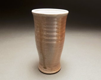 Small orange and gray wood fired tumbler with clear glaze and trailing green ash drip