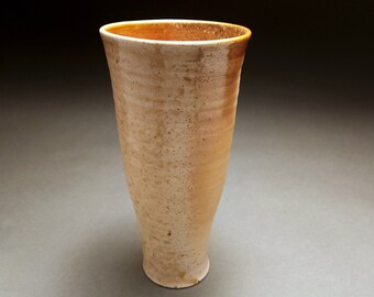 Tall wood fired tumbler with pale ash marks and orange glaze