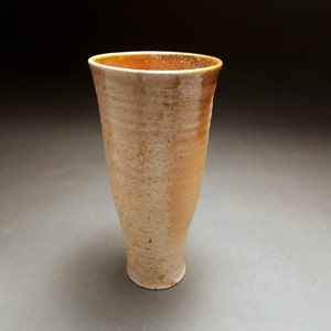 Tall wood fired tumbler with pale ash marks and orange glaze