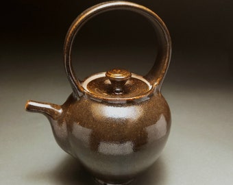 Large metallic brown tea pot with red speckles and built in tea leaf strainer