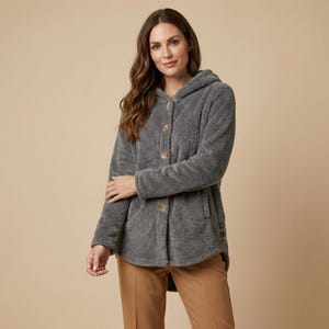 May include: A grey hooded jacket with wooden buttons. The jacket has a soft, fuzzy texture and a relaxed fit. The jacket has a hood and pockets. The model is wearing brown trousers.