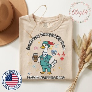 May include: Beige t-shirt with a cartoon goose in a medical uniform, holding a coffee cup. Text reads "Respiratory Therapist Silly Goose" and "COVID Front Line Hero." The shirt also features medical symbols and the phrase "Pandemic Fuel."
