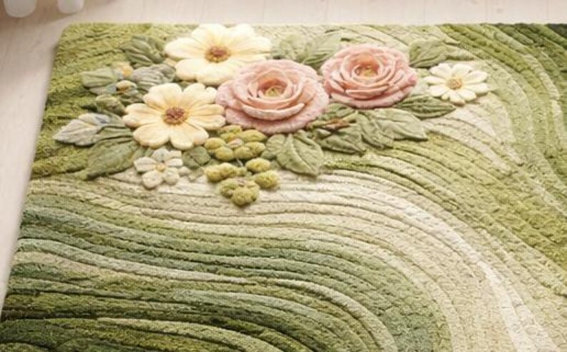 May include: A rectangular rug with a floral design. The rug features a pattern of green and cream-colored curved lines. The top of the rug has 3D flowers in shades of pink, yellow, and white, with green leaves and small green clusters.
