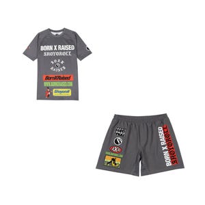Könnte beinhalten: Ein graues Set aus T-Shirt mit kurzen Ärmeln und Shorts mit verschiedenen Grafikdrucken. Das T-Shirt zeigt BORN X RAISED, SHOYOROLL und Website-Text. Die Shorts zeigen den Text BORN X RAISED SHOYOROLL und mehrere Logos in Rot, Grün und Schwarz.