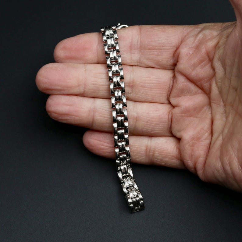 A vintage sterling silver panther style link bracelet made in Italy is displayed on a hand for scale
