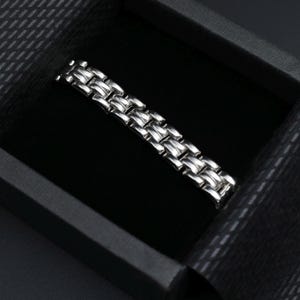 A vintage sterling silver panther style link bracelet made in Italy is displayed on a dark background shown in the gift packaging your bracelet will arrive in