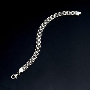 A vintage sterling silver panther style link bracelet made in Italy is displayed on a dark background