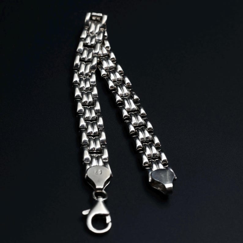 A vintage sterling silver panther style link bracelet made in Italy is displayed on a dark background this view shows how the links are the same on each side
