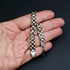 A vintage sterling silver panther style link bracelet made in Italy is displayed on a hand for scale and this photo also shows how the links are double sided