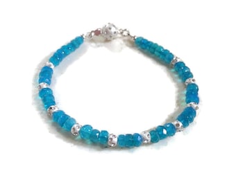 May include: A turquoise blue gemstone bracelet with silver beads and a silver clasp.