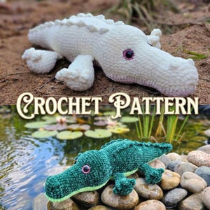 Pode incluir: Dois brinquedos de pelúcia de crochê de jacaré são exibidos. Um é branco, o outro é verde. Ambos têm olhos cor-de-rosa e estão deitados. O texto "CROCHET PATTERN" é exibido em uma fonte decorativa.