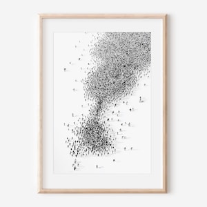 May include: Black and white art print of a crowd of people, forming a shape that resembles an exclamation point. The print is framed in a light-colored wooden frame. The artwork is a minimalist, abstract representation of a large group of people.