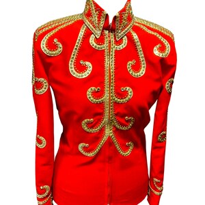 May include: A bright red jacket with gold detailing. The jacket has a high collar and long sleeves, decorated with elaborate gold scroll patterns and studs. A gold zip fastens the front. This is a striking piece of clothing.