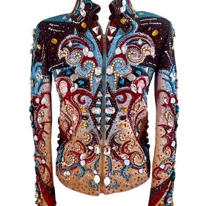 Könnte beinhalten: Dekorative Jacke in Braun-, Beige- und Blautönen. Sie ist mit roten, blauen und klaren Edelsteinen und Perlen verziert. Die Jacke hat einen Reißverschluss und einen hohen Kragen. Das Design ist aufwendig.