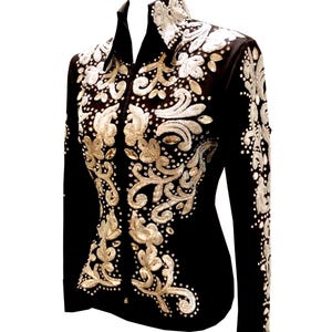 Puede incluir: Chaqueta de concurso de equitación negra con intrincado bordado floral plateado y dorado. La chaqueta presenta un cuello alto, mangas largas y un corte entallado. Adornada con pedrería, la chaqueta está diseñada para la equitación competitiva.