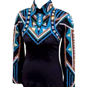 May include: Black long-sleeved shirt with detailed geometric patterns in turquoise, brown, and clear rhinestones. The shirt has a high collar and is adorned with sparkling accents, creating a striking visual effect. The design is symmetrical and eye-catching.