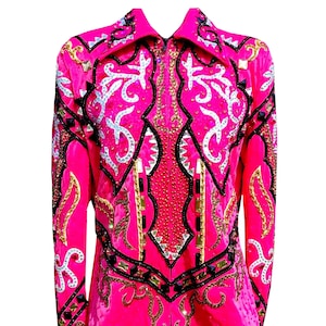 Puede incluir: Una chaqueta de exhibición ecuestre rosa brillante con adornos elaborados. La chaqueta presenta intrincados patrones en oro, negro y plata, con una cremallera frontal y un cuello clásico. El diseño incluye cuentas decorativas y detalles brillantes.