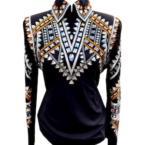 Könnte beinhalten: Schwarzes Langarmhemd mit dekorativem Kragen und aufwendigen Verzierungen. Das Hemd hat eine schillernde Anordnung aus silbernen, orangefarbenen und klaren Kristallen und Strasssteinen in geometrischen Mustern.