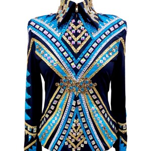 Könnte beinhalten: Dunkelblaues Reitturniershirt mit Reißverschlusskragen. Das Shirt hat ein geometrisches Design mit türkisfarbenen, goldenen und silbernen Verzierungen. Die Ärmel haben ebenfalls türkisfarbene Akzente. Für Reitveranstaltungen.