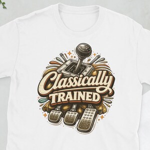 Może przedstawiać: Biała koszulka z grafiką w stylu vintage przedstawiającą dźwignię zmiany biegów, pedały i napis "Classically Trained". Projekt wykorzystuje brązowe, beżowe i złote kolory.