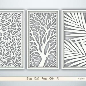 May include: Three white framed wall art panels with intricate cut-out designs. The panels feature leaf, tree, and palm frond patterns. The bottom of the image displays the text "Svg Dxf Rng Cdr Ai Digital files."