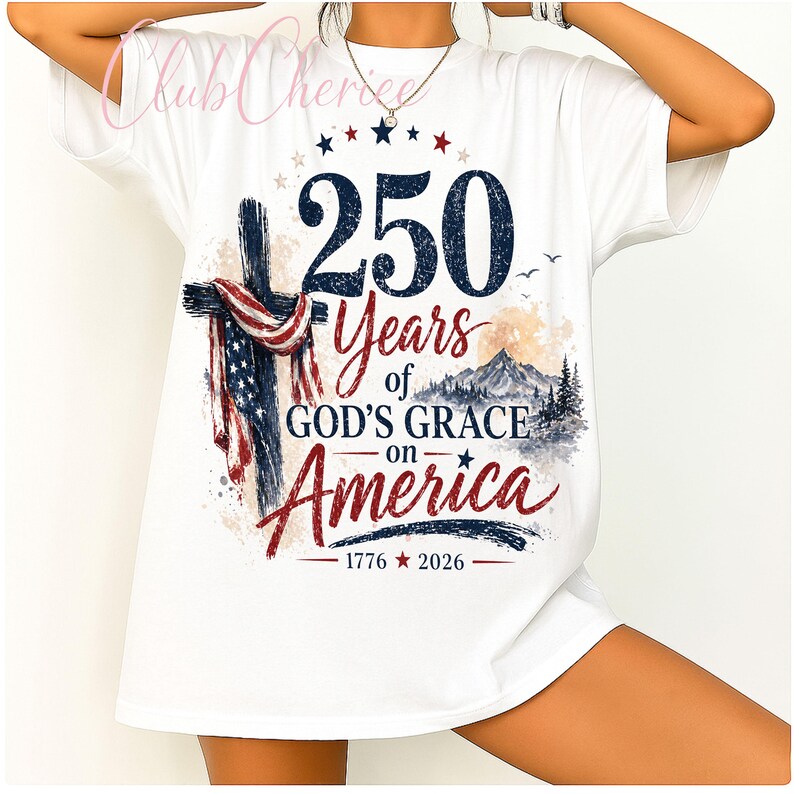 K&ouml;nnte beinhalten: Ein wei&szlig;es T-Shirt mit einem grafischen Design, das ein Kreuz mit einer amerikanischen Flagge, eine Berglandschaft und den Text 250 Years of GOD'S GRACE on America 1776-2026 zeigt. Das Design enth&auml;lt rote, wei&szlig;e und blaue Farben sowie Sterne.