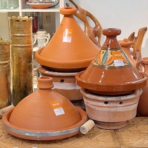 May include: A set of three ceramic mugs with a speckled, matte finish. Each mug features a different color: light blue, cream, and gray. The mugs have a simple, modern design and a comfortable handle.