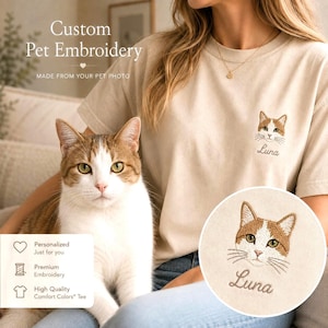 May include: A beige short-sleeved t-shirt featuring custom pet embroidery of a brown and white cat face with the name Luna stitched underneath. The text Custom Pet Embroidery and MADE FROM YOUR PET PHOTO is visible on the upper left side.