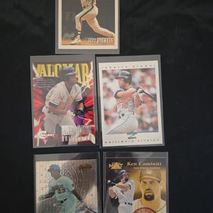Peut inclure: Plusieurs cartes de baseball à collectionner, chacune représentant un joueur en action. Les cartes sont dans des pochettes de protection et présentent des noms tels que Jeff Bagwell, Roberto Alomar, Raul Mondesi et Ken Caminiti. Les cartes ont des designs et des couleurs variés.
