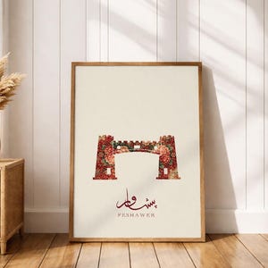 Pode incluir: Uma impressão de arte emoldurada com um design floral de uma ponte ou portão. A obra de arte tem um fundo creme com a palavra "PESHAWER" em um script vermelho escuro. A ponte é preenchida com um padrão floral em tons de vermelho e rosa.
