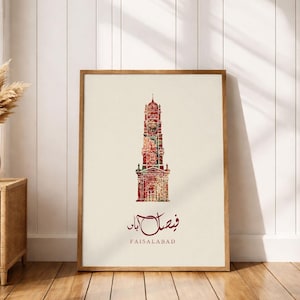 Pode incluir: Uma impressão artística emoldurada com uma ilustração detalhada de uma estrutura alta e ornamentada em tons de vermelho e castanho. A obra de arte inclui escrita árabe e a palavra em inglês "FAISALABAD" na parte inferior, sobre um fundo creme.