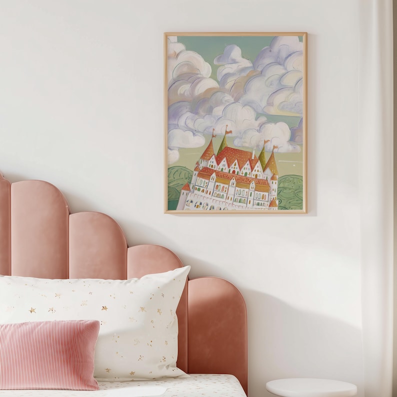 May include: A framed art print featuring a whimsical illustration of a castle with red roofs and white walls, set against a backdrop of fluffy clouds and a green landscape. The artwork is in a wooden frame.