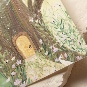 May include: A whimsical illustration of a fairy door nestled in a tree trunk, surrounded by lush greenery and delicate white and purple flowers. A white peacock stands nearby, adding to the enchanting scene. The artwork evokes a sense of fantasy and nature.