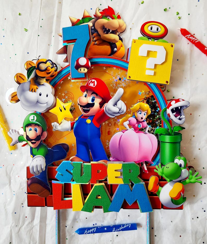 May include: A colorful Super Mario-themed birthday cake topper. The topper features Mario, Luigi, Princess Peach, Yoshi, Bowser, and other characters. The number 7 is displayed, along with the name "Liam" and the words "Happy Birthday".