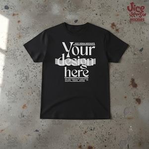 May include: Black crew neck t-shirt with the text "Your design here" in white. The shirt also has the text "VICE VERSA MOCKUPS" above the main text and additional text below. The shirt is displayed on a textured gray surface.