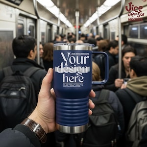 May include: A navy blue travel mug with a handle, featuring the text "Your design here" in white. The mug has a silver rim and a ridged design around the base. The background shows a crowded subway car.