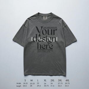 May include: A gray t-shirt with the text "Your design here" in a bold, stylized font. The shirt has a crew neck and short sleeves. Measurements are provided for various sizes, with widths ranging from 18.25 to 29.75 inches and lengths from 26.6 to 33.5 inches.