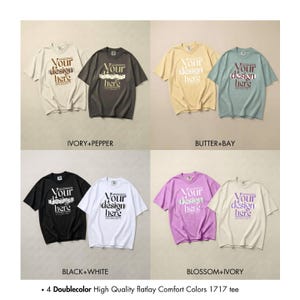 May include: A collection of short-sleeved t-shirts in various colors, including ivory, pepper, butter, bay, black, white, blossom, and ivory. Each shirt features the text "Your design here" in a contrasting color.
