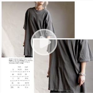 May include: A gray oversized t-shirt made of Comfort Colors 1717® Pepper fabric. The shirt has short sleeves and a relaxed fit. The image includes a size chart with measurements in inches for width and length, ranging from size S to 2XL.